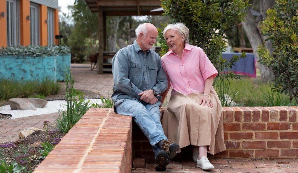 Colin and Maggie Beer, on the bench between the original Farmshop and daughter Elli’s Eatery on reopening after COVID lockdown reminiscing about their journey. featured image