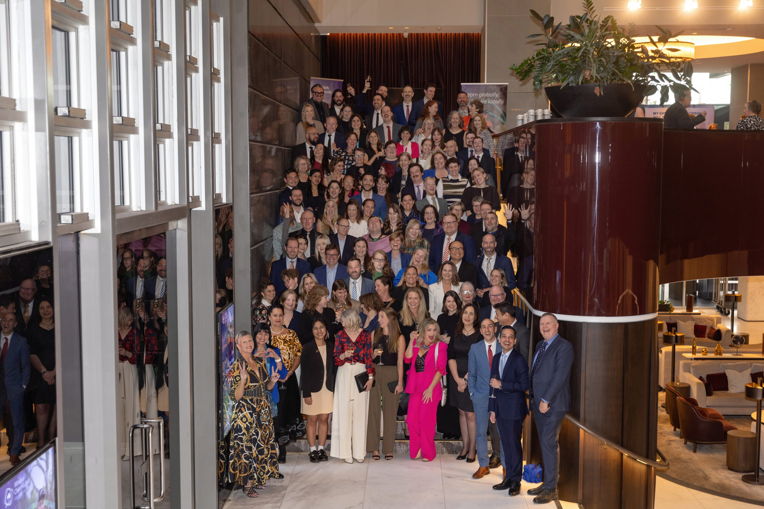 Approx 100 Churchill Fellows gather on a staircase and pose for a photo featured image