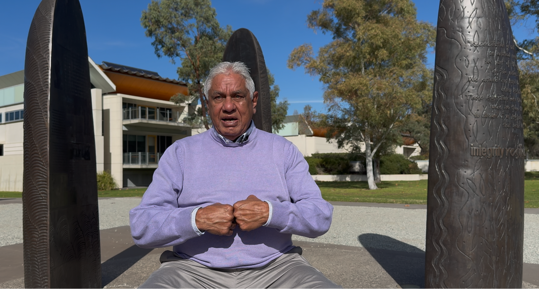 Joseph Flick sitting at the Stolen Generation sculpture on the Reconciliation path at Lake Burley Griffin in Canberra featured image